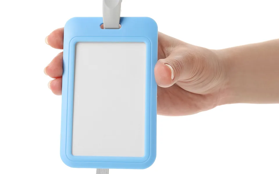 Hand holding a pale blue ID card holder on a lanyard with a blank white card inside